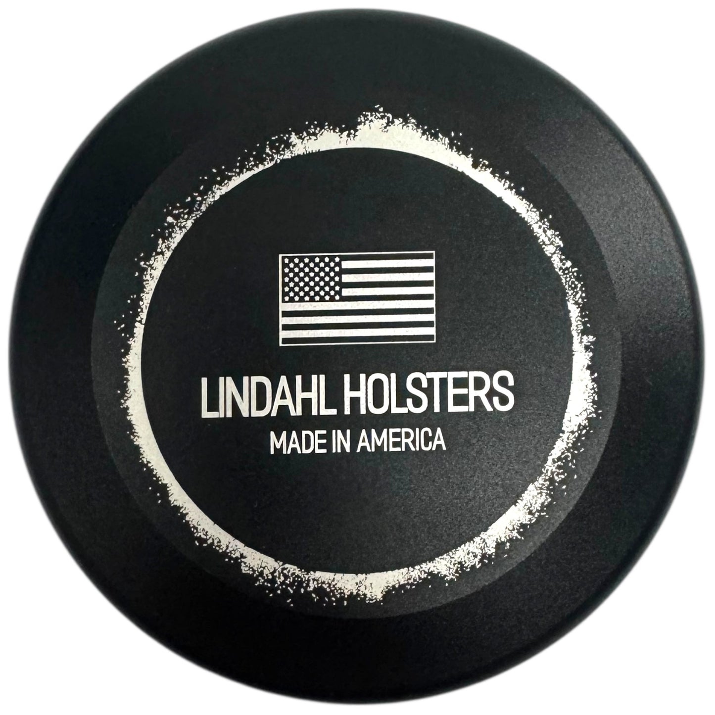 Black round object with 'Lindahl Holsters Made in America' text and American flag logo on a white background