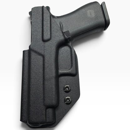 A black textured polymer or leather holster containing a handgun, photographed on a clean white background.